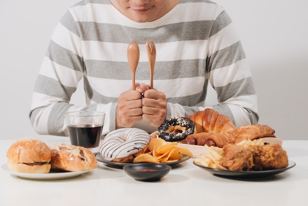 Jonge man thuis met een ongezond dieet