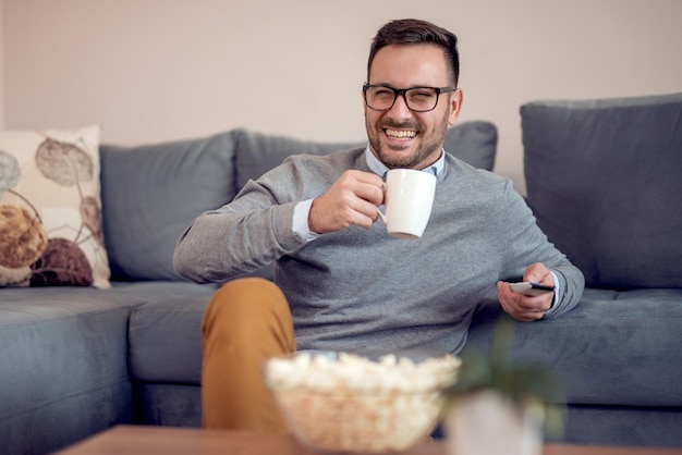 Jonge man thuis tv kijken op een bank