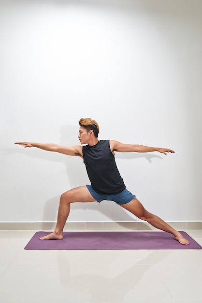 Jonge man trainen op oefenmat, binnenshuis