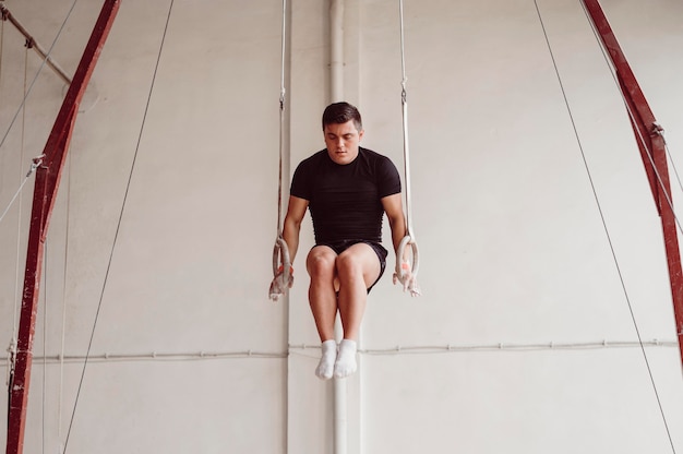 Foto jonge man training op gymnastiek ringen