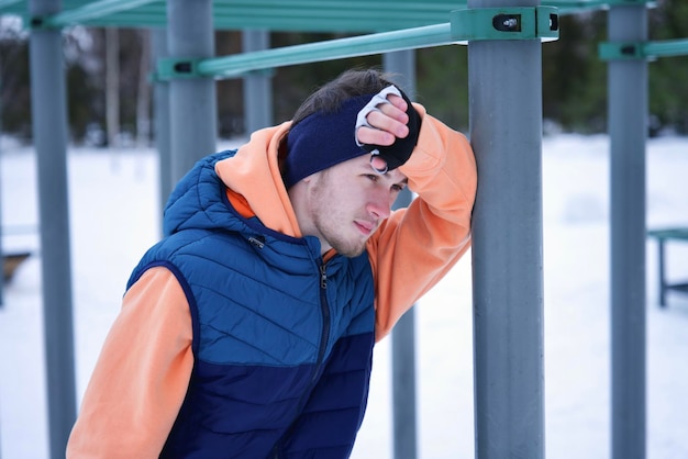 Jonge man traint fitness buiten op een koude sneeuwige winterdag gezonde fitness levensstijl