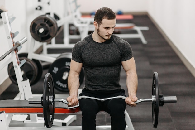 Jonge man traint zijn lichaam om fit te blijven en gedefinieerde spieren te hebben