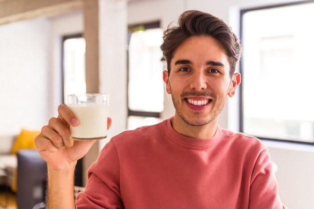 Jonge man van gemengd ras die melk drinkt als ontbijt