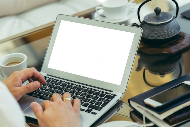 Jonge man voert werk op een laptop