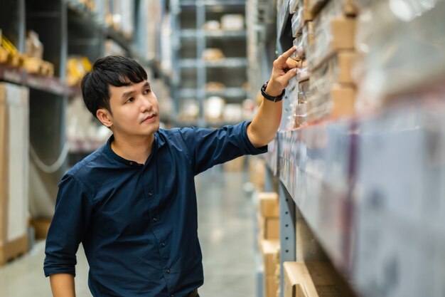 Jonge man werknemer inventaris in het magazijn te controleren