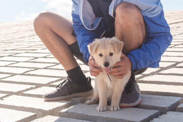 Jonge man zijn puppy buiten aaien.