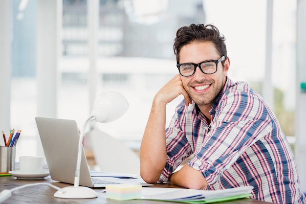 Jonge man zit aan zijn bureau