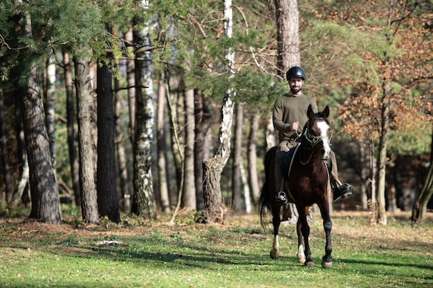 Jonge man zit buiten op een paard