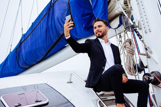 Foto jonge man zit op een boot tegen de blauwe hemel.