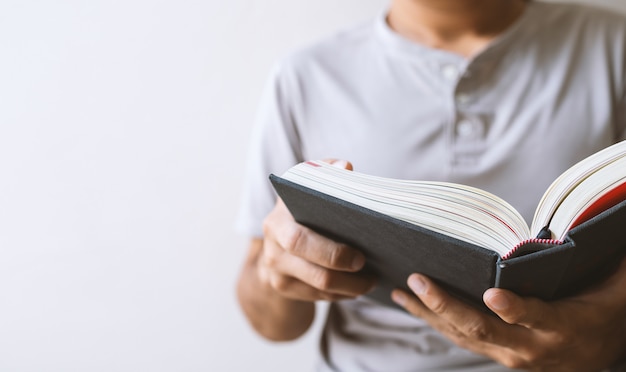 Jonge man zit te lezen in het raam in de kamer