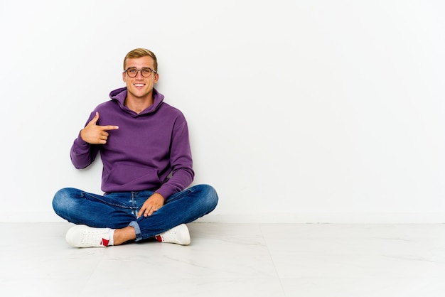 Jonge man zittend op de vloer persoon met de hand te wijzen