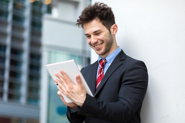 Jonge manager die een digitale tablet in openlucht gebruikt