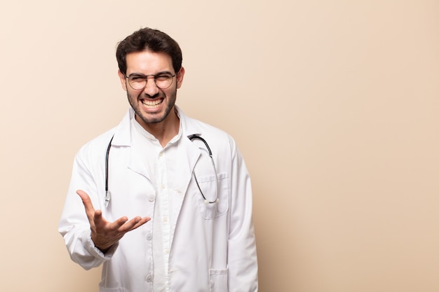 Jonge mannelijke arts die boos, geïrriteerd en gefrustreerd schreeuwend wtf kijkt