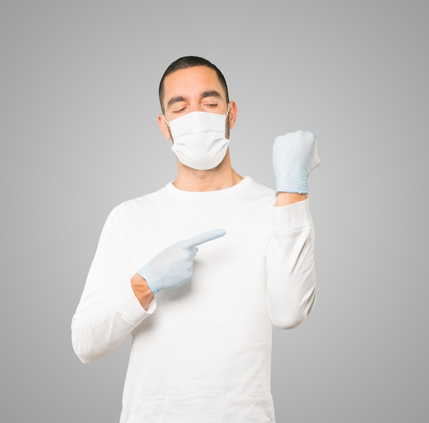 Jonge mannelijke arts die masker en beschermende handschoenen draagt
