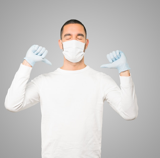 Jonge mannelijke arts die masker en beschermende handschoenen draagt