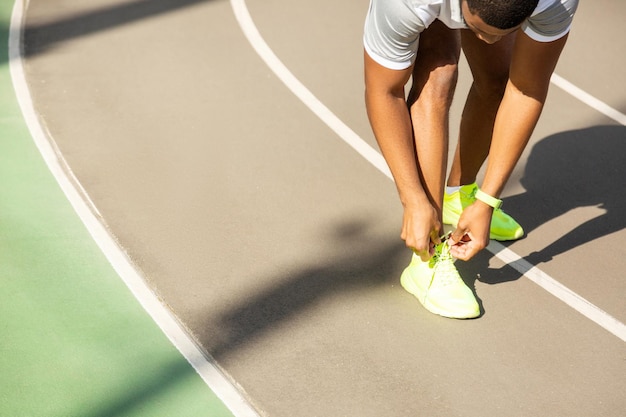 Jonge mannelijke atleet die veters bindt in het stadion