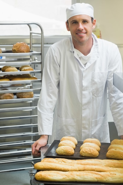 Jonge mannelijke bakker die zich in een keuken bevindt