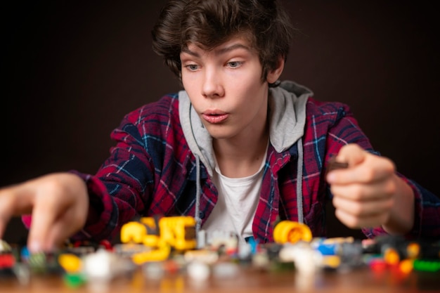 Jonge mannelijke constructie speelgoedbakstenen op houten tafel kind speelgoed jeugd b