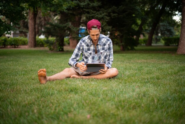 Jonge mannelijke freelancer die aan een tablet werkt en de tekst typt