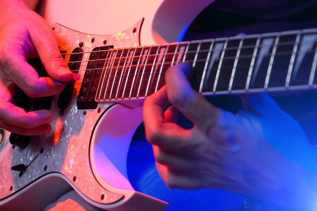 Jonge mannelijke muzikant met een witte gitaar