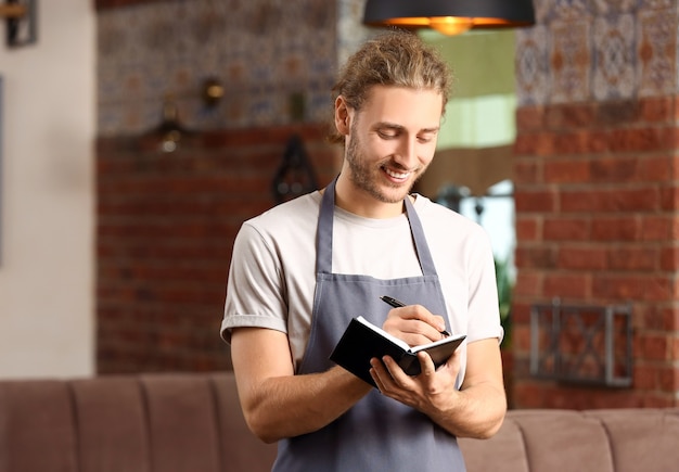 Foto jonge mannelijke ober in restaurant