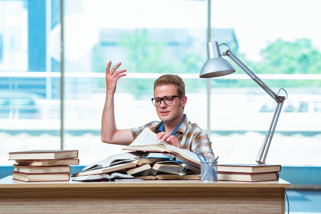 Jonge mannelijke student die voor middelbare schoolexamens voorbereidingen treft