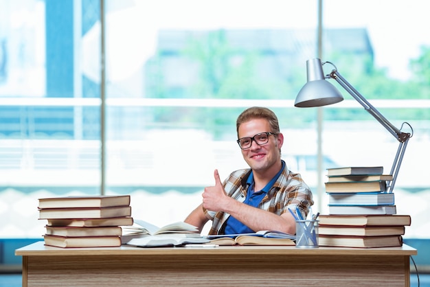 Jonge mannelijke student die voor middelbare schoolexamens voorbereidingen treft