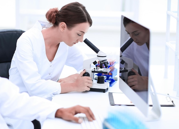 Jonge mannelijke technicus die aan computer in laboratorium werkt