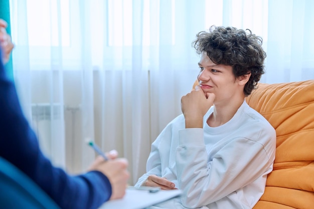 Jonge mannelijke universiteitsstudent in therapie sessie met psycholoog