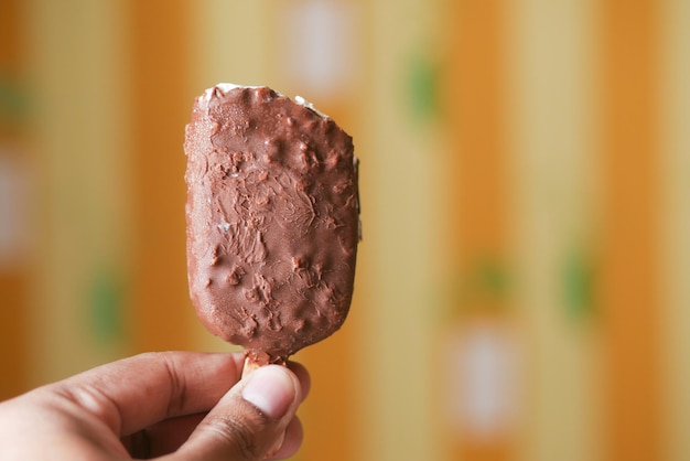 Jonge mannen die ijs met chocoladesmaak eten