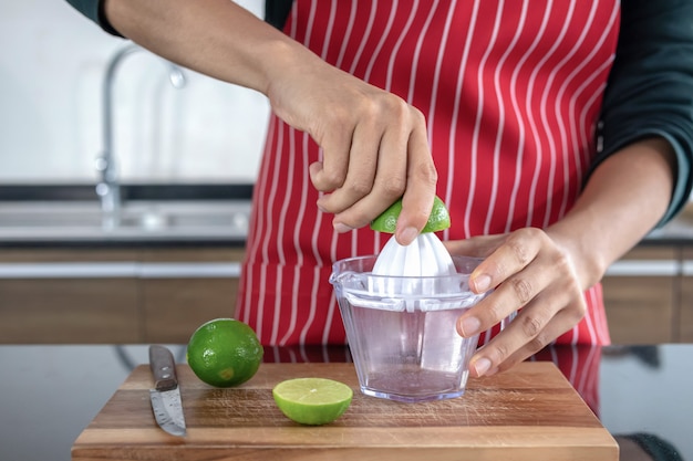 Jonge mannen die limonade in de keuken drukken