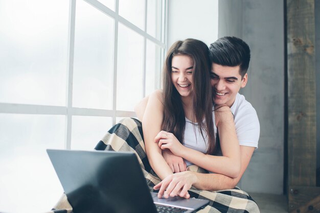 Jonge mannen en vrouwen werken aan de computer of zoeken informatie op het internet bij een raam vol zonlicht