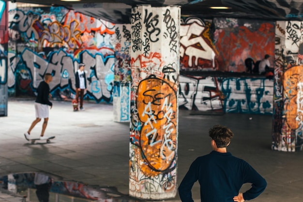 Jonge mannen in het graffiti skateboardpark.