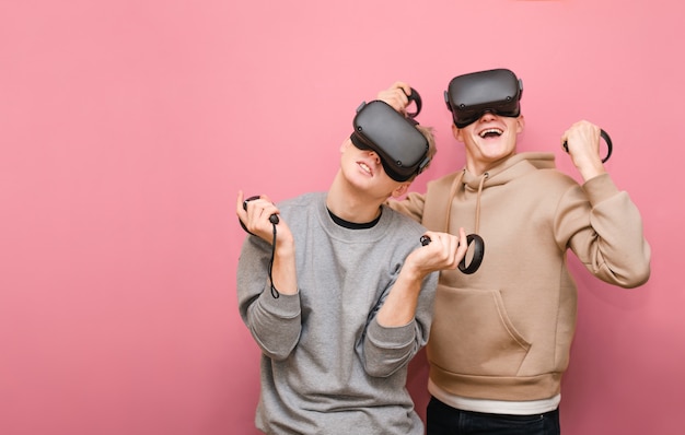 Jonge mannen met controller en Vr-helmen die videogames spelen