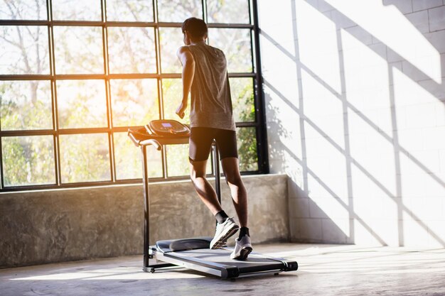 Foto jonge mannen trainen op een automatische loopband