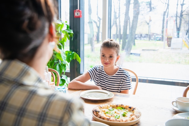 Jonge meisjes chatten aan de keukentafel