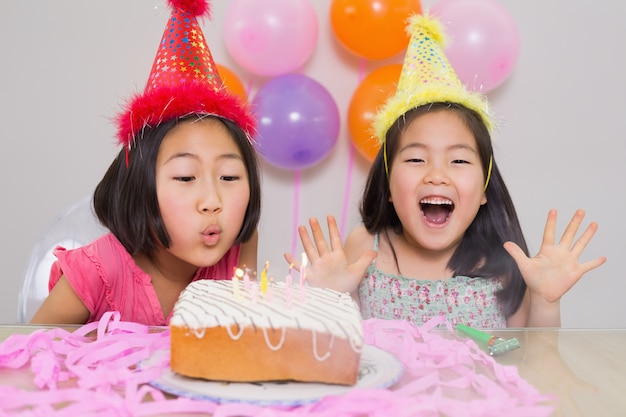 Jonge meisjes die cake blazen bij een verjaardagspartij