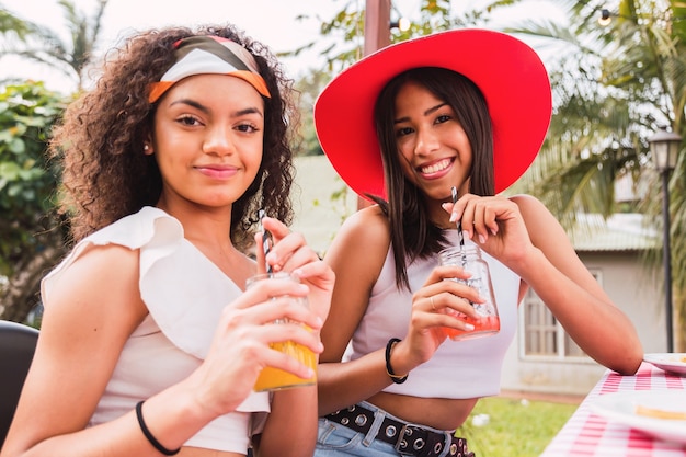 Jonge meisjes die van de dag genieten die sap drinken