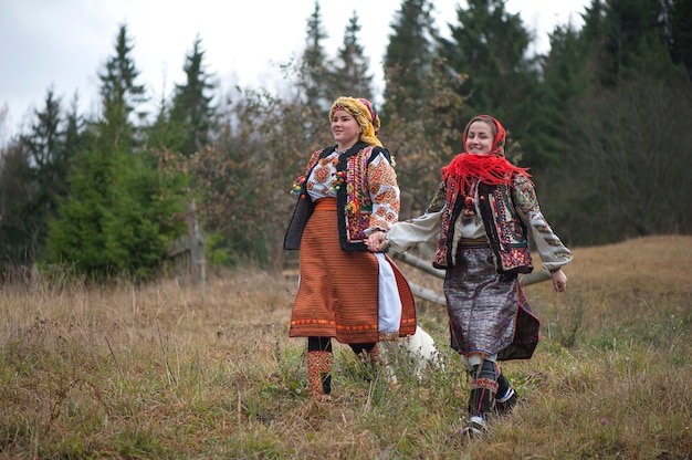 Jonge meisjes in de nationale kleren van Hutsul die in de Karpaten lopen.