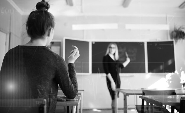 Jonge meisjesleraar op de basisschool in de klas voor bord