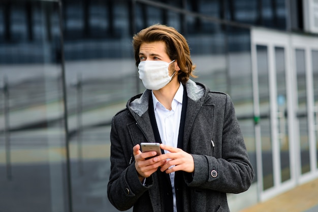 Jonge mens die een gezichtsmasker buiten draagt