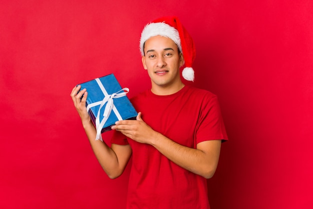 Jonge mens die een gift op Kerstmisdag houdt