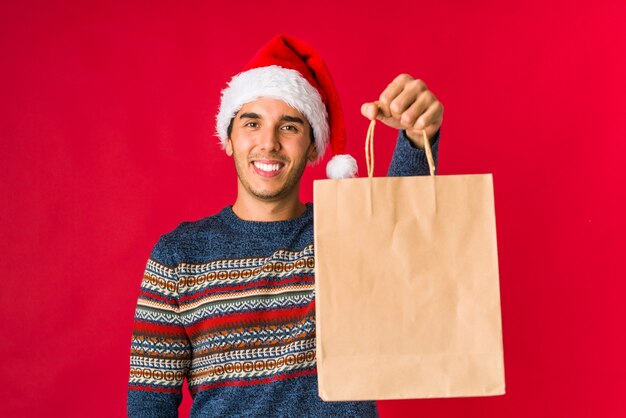 Jonge mens die een gift op Kerstmisdag houdt