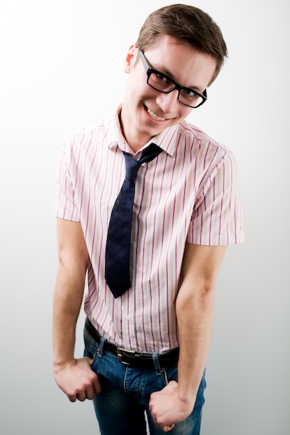 Foto jonge mens die in bedrijfs toevallige kleding in glazen over wit glimlachen
