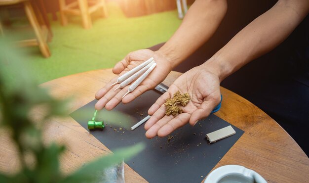 Foto jonge mens die sigaretten met medische marihuana maakt