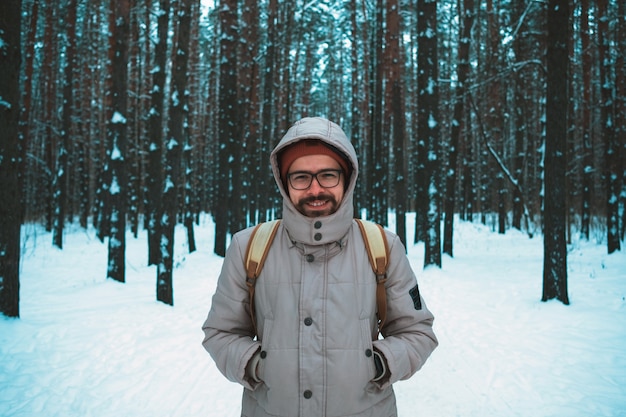 Jonge mens die zich in de winter sneeuwbos bevindt