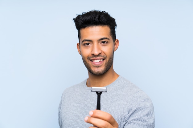 Jonge mens die zijn baard met gelukkige uitdrukking scheert