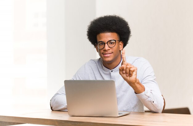 Jonge mens die zijn laptop met behulp van die nummer één toont