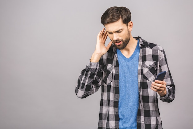 Jonge mens het luisteren muziek gebruikend telefoon en dansend over grijze muur. Geïsoleerd.