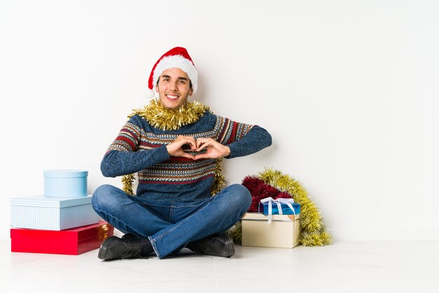 Jonge mens op Kerstmisdag die een welkome uitdrukking toont.